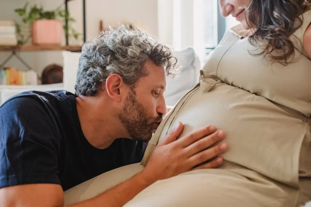 Pai beijando barriga de esposa grávida